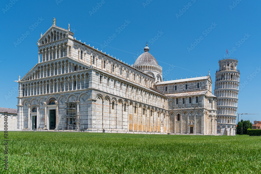the Leaning Tower of Pisa and the Cathedral of Pisa in front of a bright blue sky