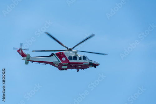 a helicopter flies in the blue sky