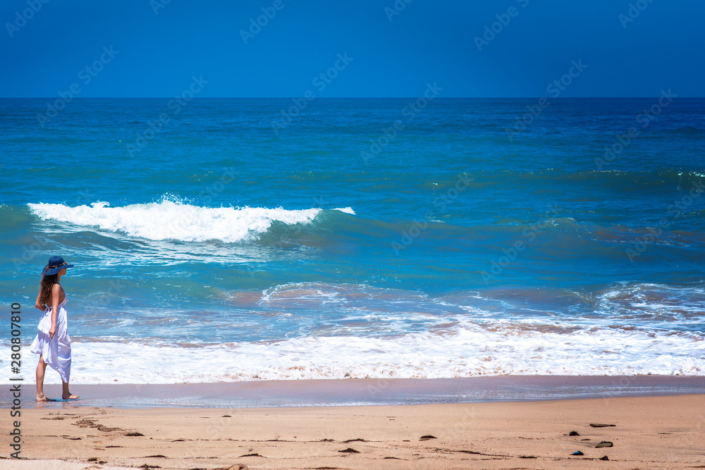 Young girl walking by the coastline enjoying summer traveling Young girl walking by the coastline enjoying summer traveling