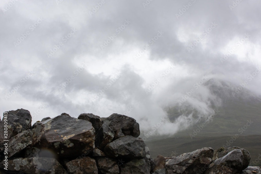 Stonewall with misty white mountain in the background