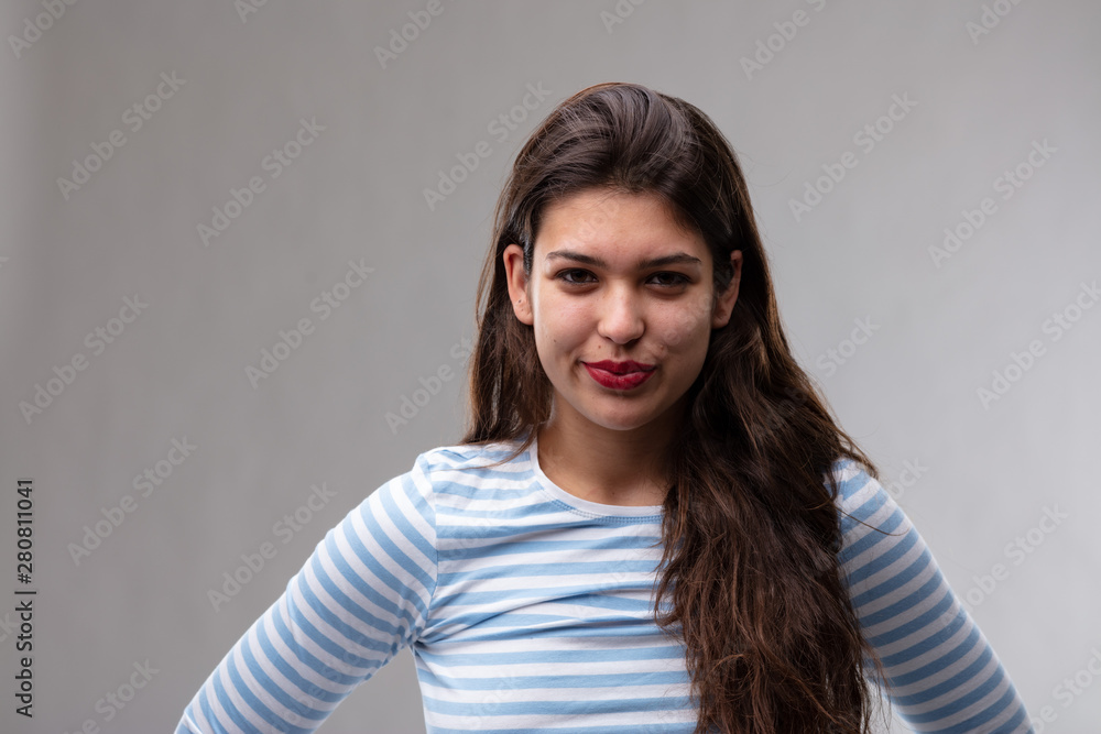 Amused young woman grinning at the camera Amused young woman grinning at the camera