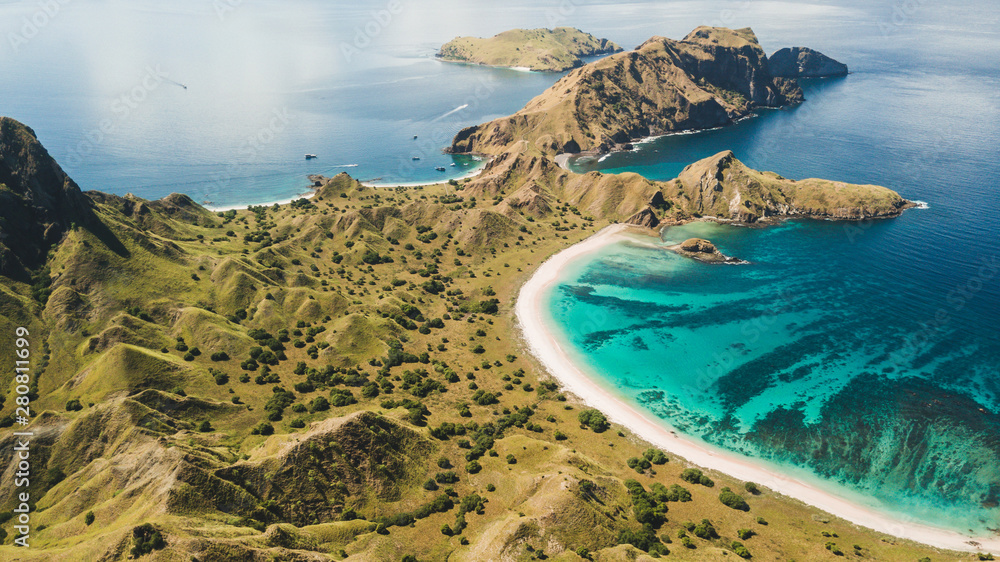 Aerial panoramic view of Padar island in Komodo National Park, Indonesia. Drone shot, top view. Green hills and amazing beautiful coastline. Tropical background. - obrazy, fototapety, plakaty 