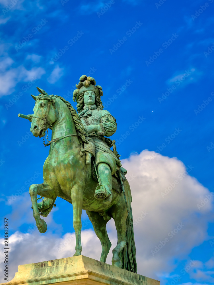 Obraz premium Versailles, France - April 24, 2019: Louis XIV statue just outside of the gates of Versailles Palace on a sunny day outside of Paris, France.