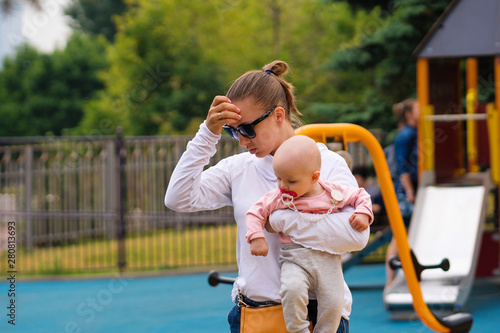 Mom holds the little daughter in her arms. Good relations of parent and child. Happy moments together. photo