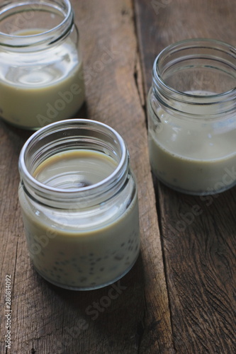 black sesame soy milk in glass on wood