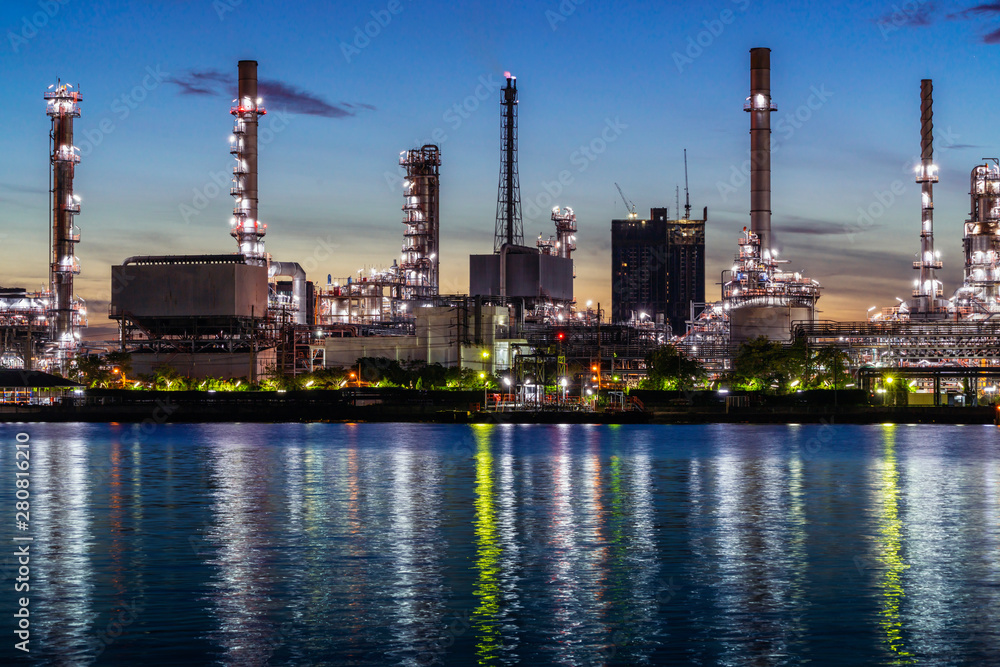 refinery oil petroleum production factory with river reflecting surface sunrise morning sky