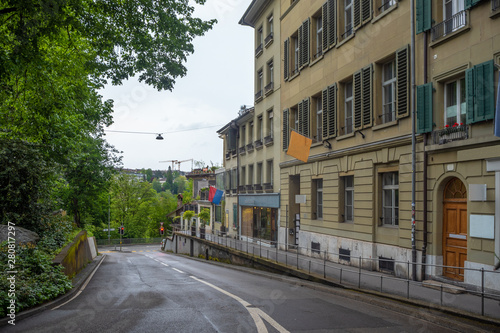 Beautiful scene of empty street with medieval buildings and lush trees in old town of Bern, Switzerland