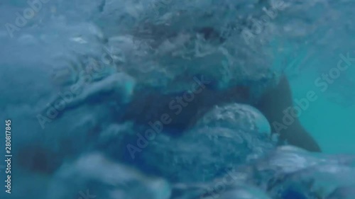 SELFIE Smiling man sliding down super fast water slide in waterpark on a beautiful summer day