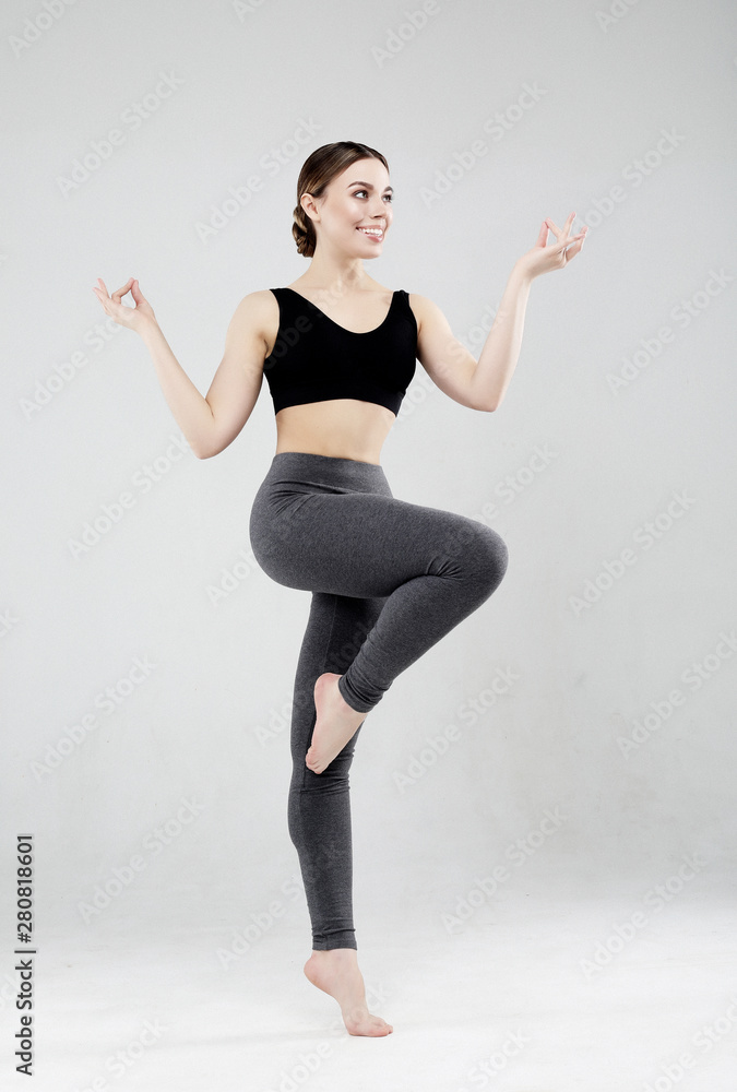 Sport, fitness and people concept: Beautiful young woman dressed in sportswear jumping up over grey background
