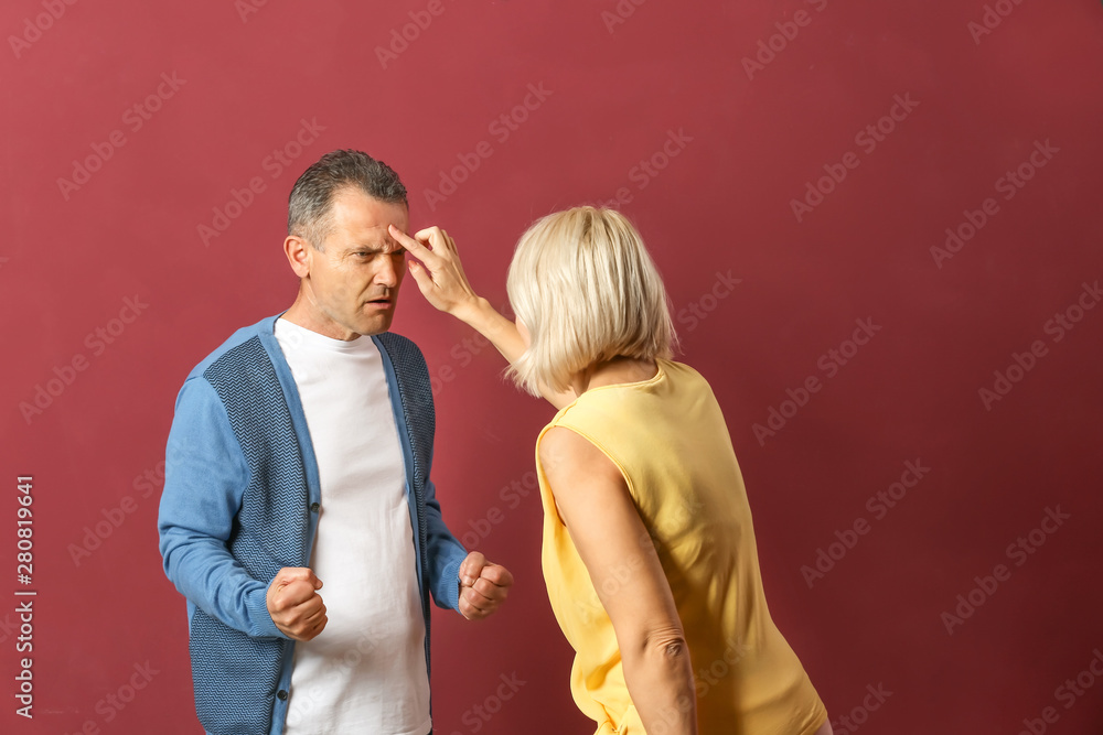 Obraz premium Quarrelling middle-aged couple on color background