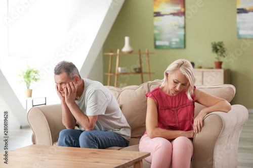 Sad middle-aged couple after quarrel at home