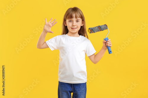 Little girl with paint roll...