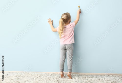 Little girl painting on col...