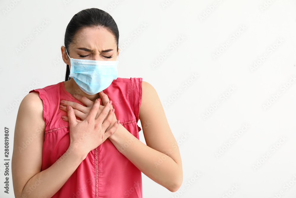 Young woman wearing protective mask on light background Young woman wearing protective mask on light background