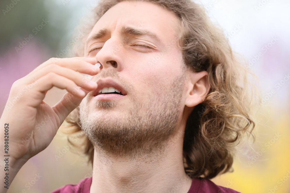 Fototapeta premium Young man with nasal drops on spring day