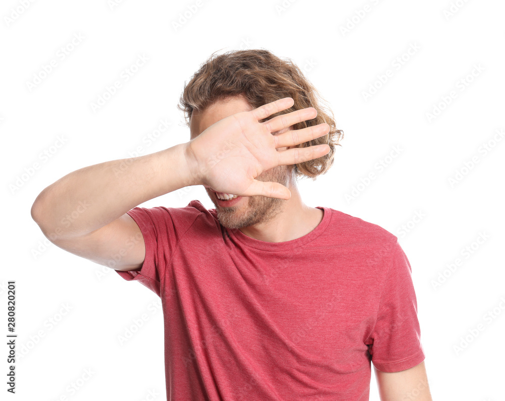 Young man covering his eyes on white background Young man covering his eyes on white background