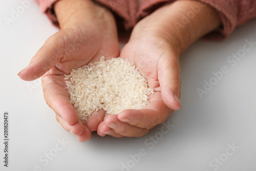Foto Hands of elderly woman with rice on white background