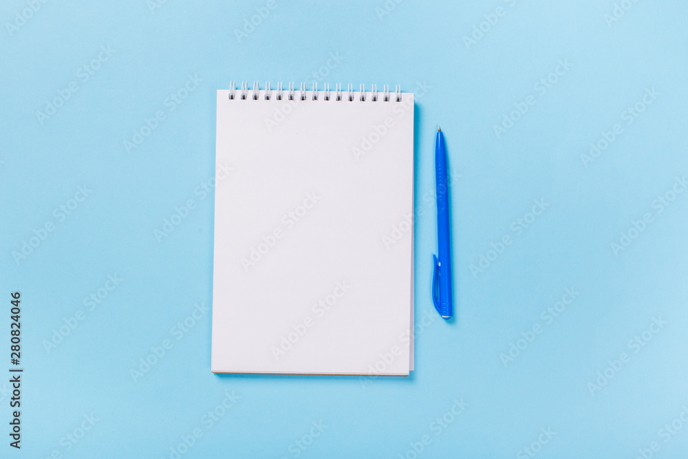 school notebook on a blue background, spiral notepad on a table school notebook on a blue background, spiral notepad on a table