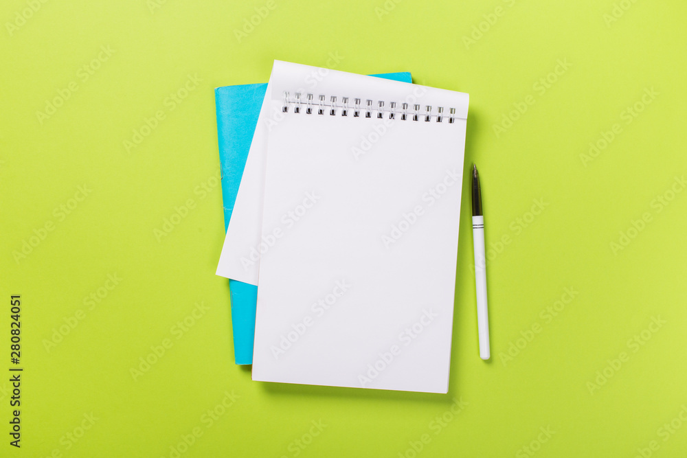 school notebook on a green background, spiral notepad on a table. school notebook on a green background, spiral notepad on a table.