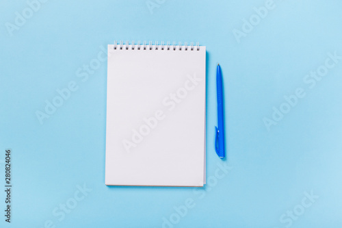 school notebook on a blue background, spiral notepad on a table