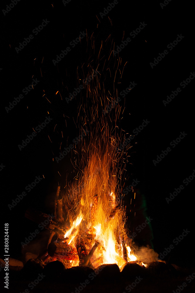 A campfire with sparks at night. A campfire with sparks at night.