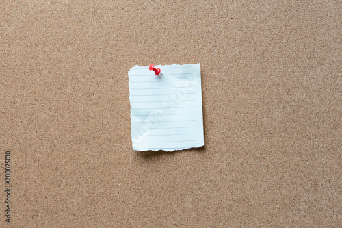 note paper with tack on a cork bulletin board
