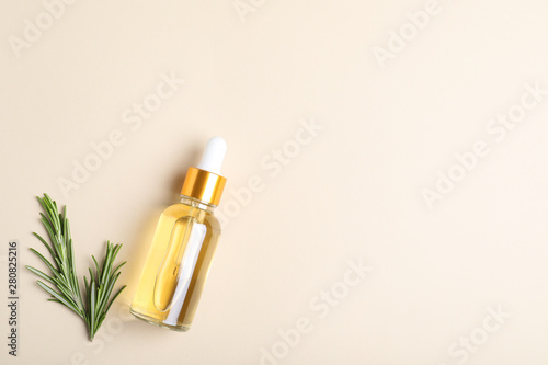 Flat lay composition with rosemary essential oil and space for text on beige background