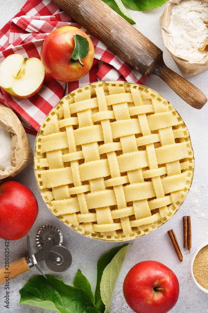 Raw unbaked apple pie with tools and ingredients for cooking. Raw unbaked apple pie with tools and ingredients for cooking.