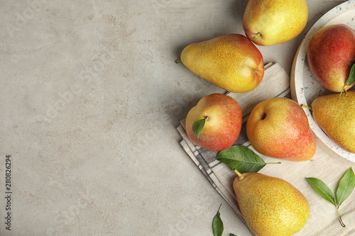 Photos Ripe juicy pears on grey stone table, flat lay. Space for text