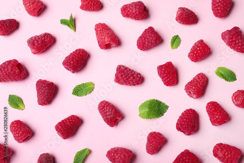 Flat lay composition with delicious ripe raspberries on pink background