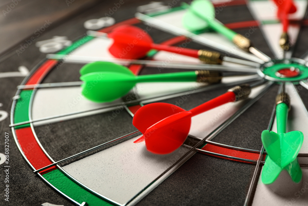Red and green arrows on dart board, closeup Red and green arrows on dart board, closeup