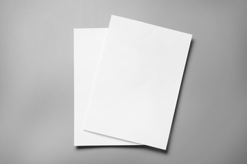 Blank paper sheets for brochure on grey background, top view. Mock up