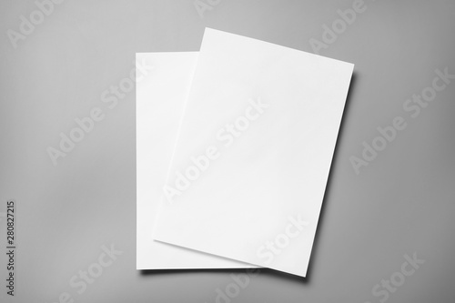 Blank paper sheets for brochure on grey background, top view. Mock up photo