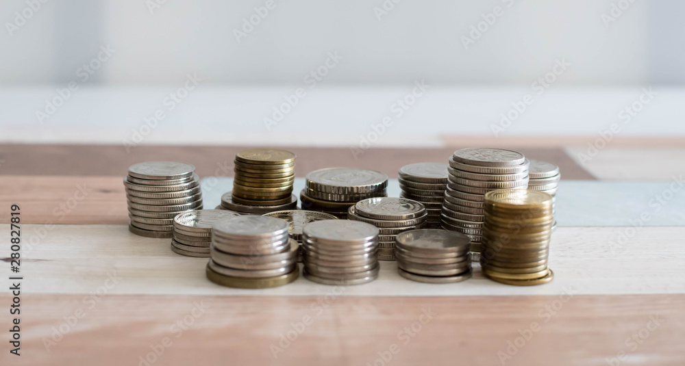 Stack money coin for growing your business. Savings, increasing columns of coins isolated on white background and wooden table Stack money coin for growing your business. Savings, increasing columns of coins isolated on white background and wooden table