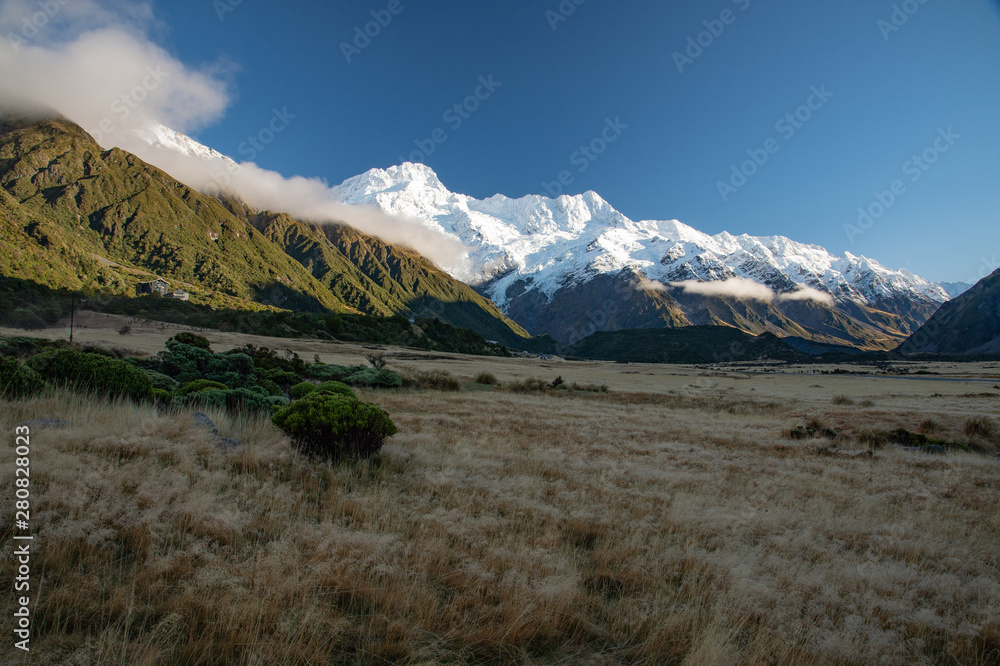 Magnificent landscape of white snow covered top of mountain with clear blue sky and invisibly medow of the great Aroki Mount Cook National Park, South New Zealand.