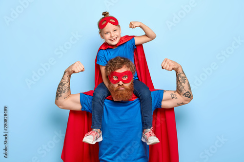 Fotografia Strong powerful dad and little female child on his shoulders show muscles, ready