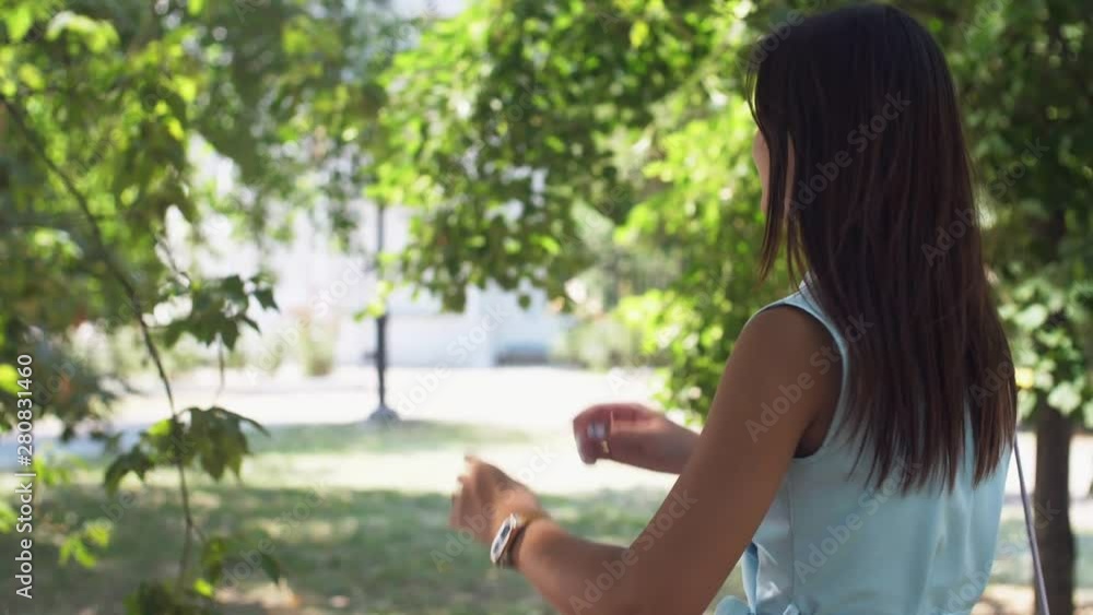 Sweet brunette girl walking and turning back to smarten up in summer in slo-mo Sweet brunette girl walking and turning back to smarten up in summer in slo-mo