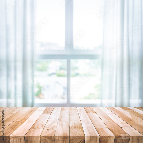 Empty of wood table top on blur of white curtain with window view background