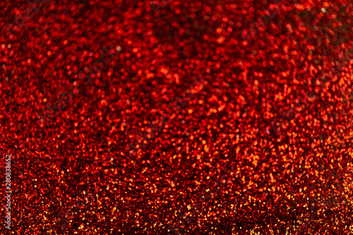 Red glitter texture abstract background on black background.