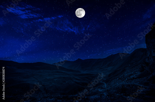 Mountain Road through the forest on a full moon night. Scenic night landscape of country road at night
