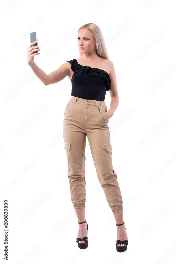 Confident modern blonde hair woman fashion lifestyle influencer taking photos with smart phone. Full body isolated on white background. Confident modern blonde hair woman fashion lifestyle influencer taking photos with smart phone. Full body isolated on white background.