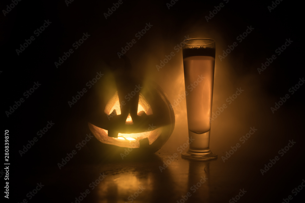 Glass of cold light beer with pumpkin on a wood background for Halloween. Glass of fresh beer and pumpkin on a dark toned foggy background Glass of cold light beer with pumpkin on a wood background for Halloween. Glass of fresh beer and pumpkin on a dark toned foggy background