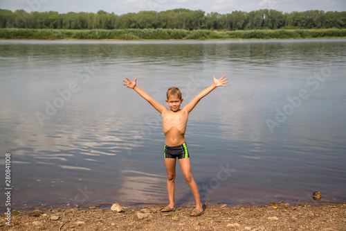 happy boy spread his arms by the river