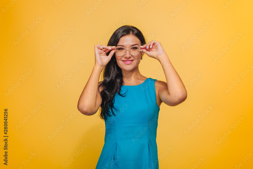 Girl on yellow background with glasses and blue dress Girl on yellow background with glasses and blue dress