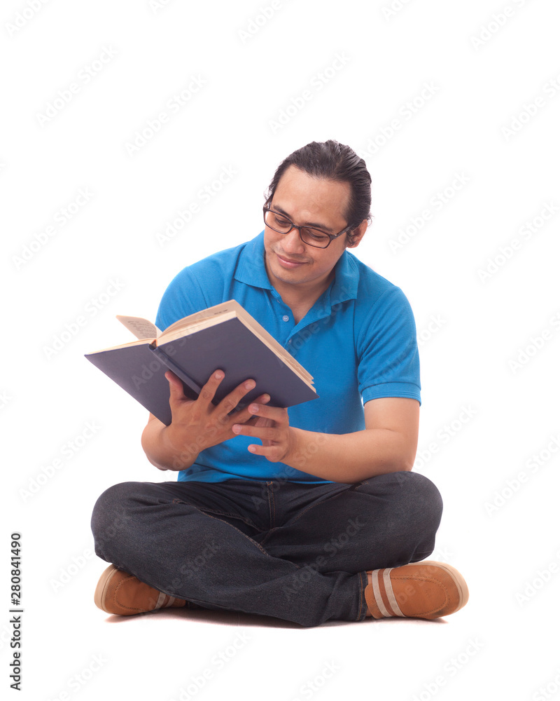Young Man Sitting on Floor and Reading a Book Young Man Sitting on Floor and Reading a Book