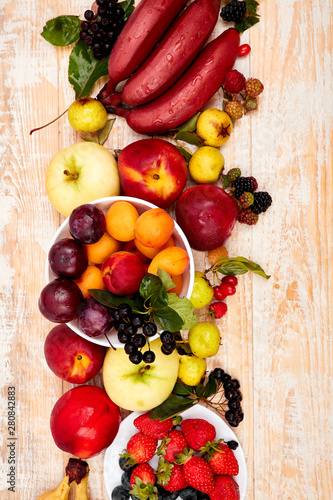Flat lay of fruits over white wooden background  top view. Vegetarian  vegan  dieting  clean eating  weight loss ingredients.  Summer fruit food background. Copy space.