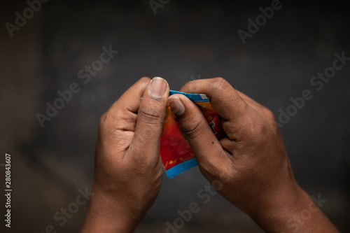 Принти на полотні Close up of a man hand tearing the Chewing tobacco, Gutka or gutkha in India