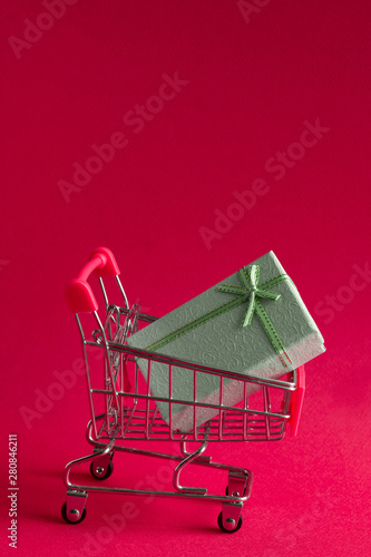 present box in a shopping cart on a pink background