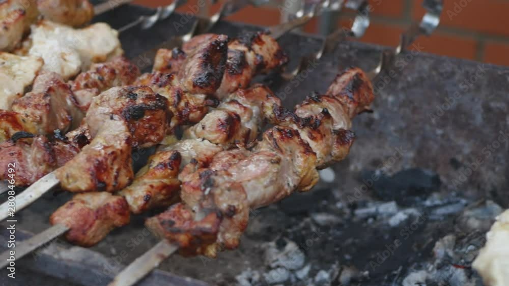 Shashlik Or Kebab Meat On Skewers Roast On Grill Outdoor Handheld Shot Shashlik Or Kebab Meat On Skewers Roast On Grill Outdoor Handheld Shot