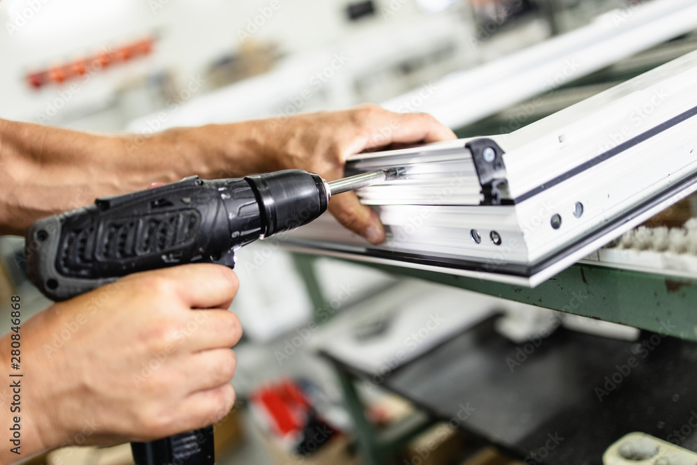 Manual worker assembling PVC doors and windows. Manufacturing jobs